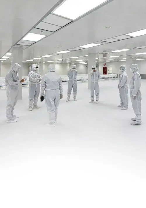 กลุ่มบุคลากรในชุดปลอดเชื้อ (Gown) รวมตัวกันภายในห้องคลีนรูมปลอดเชื้อเพื่อการฝึกอบรมหรือปฏิบัติงาน